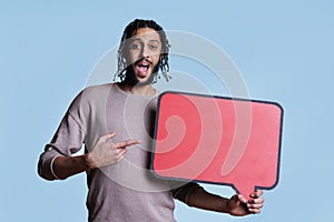 Excited arab man holding speech bubble red banner