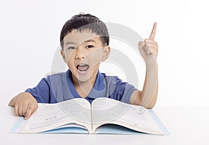 Excited asian child schoolboy studying at home