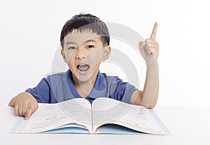 Excited asian child schoolboy studying at home photo