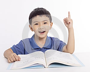 Excited asian child schoolboy studying at home and hand pointing up