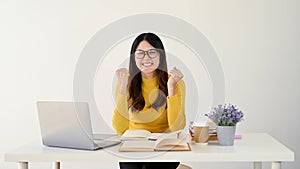 An excited Asian female is showing her fists, rejoicing.  on a white background