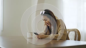 Excited asian female using mobile smart phone