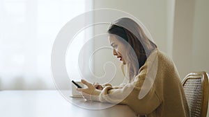 Excited asian female using mobile smart phone