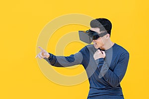 Excited Asian man reaching out hand while watching 3D simulation video from VR glasses