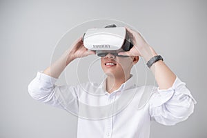 Excited asian man in a VR goggles and gesturing with his hands