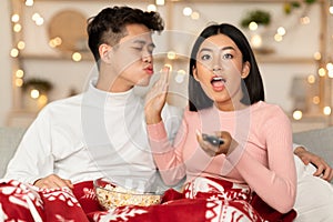 Excited Asian Wife Watching TV Refusing To Kiss Husband Indoors
