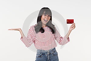 Excited Asian woman holding mockup credit card for transaction money looking at camera isolated on white background. Payment