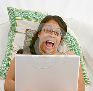 Excited Asian woman on a laptop