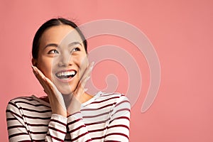 Excited Asian Woman Touching Face And Looking At Copy Space With Amazement
