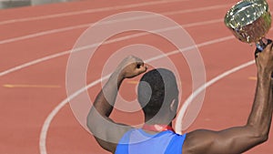 Excited athlete victoriously chanting with cup in hand, joy and triumph, success