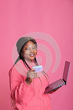 Excited attractive woman inserting credit card credentials on shopping site doing online payment