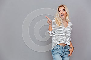 Excited attractive young woman pointing away