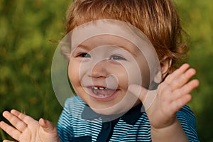 Excited baby on the meadow field. Toddler child walking outdoor, family vacations, summer season nature. Baby face close