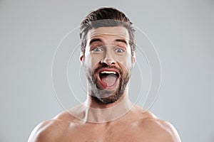 Excited bearded man with naked shoulders and open mouth