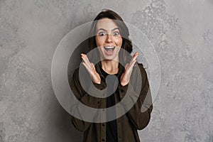 Excited beautiful brunette girl expressing surprise at camera