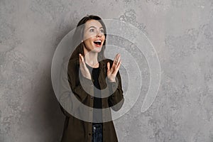 Excited beautiful brunette girl expressing surprise at camera