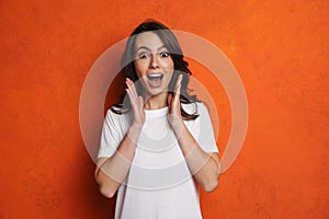 Excited beautiful brunette girl expressing surprise at camera