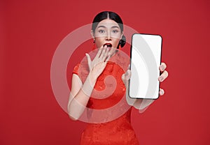 Excited Beautiful chinese Asian woman holding smartphone mockup of blank screen and smiling isolated on red background