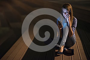 Excited beautiful girl receiving a sms message with good news in a mobile phone outside