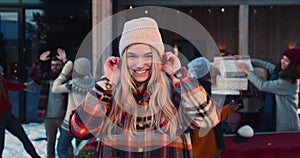 Excited beautiful happy young blonde woman in winter hat smiling at camera at fun Christmas friends party slow motion.