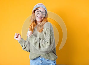 Excited beautiful young woman with closed eyes and clenched fists, isolated on yellow background. Yes concept. Good news. Pretty