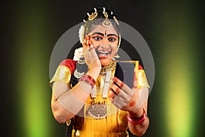 excited Bharatnatyam dancer by seeing as winner on mobile phone - concept of online shopping e-commerce offers, final photo