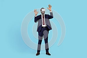 Excited Black Businessman In VR Headset Having Fun Over Blue Studio Background