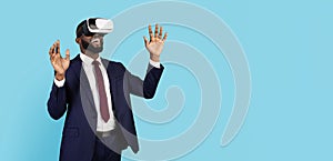 Excited Black Businessman Wearing VR Glasses And Suit Standing On Blue Background
