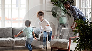 Excited black dad playing funny game with children at home