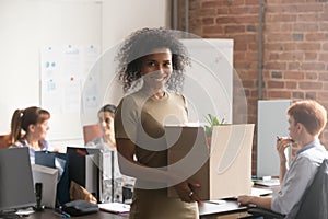 Excited black female newcomer holding box with personal belongings