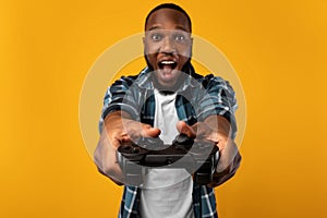 Excited Black Guy Playing Videogame Holding Game Controller In Studio