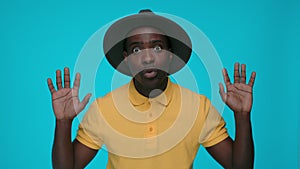 Excited black man saying wow over blue background