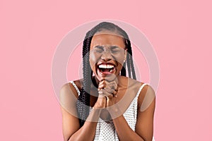 Excited black woman anticipating something wonderful, making wish, begging or praying over pink background