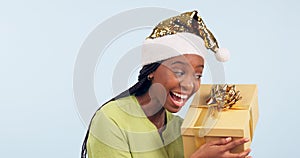 Excited black woman, box and Christmas surprise for gift, present or prize against a studio background. Face of happy