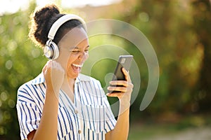 Excited black woman celebrating listening to music