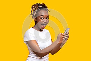 Excited black woman using mobile phone, got new nice app