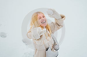 Excited blond hair girl i winter clothes outdoor. Beautiful winter woman laughing outdoors. Beauty Joyful Girl having