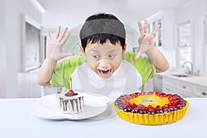 Excited boy eating dessert at home