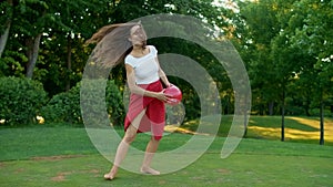 Excited boy and girl jumping in field. Joyful family playing with ball