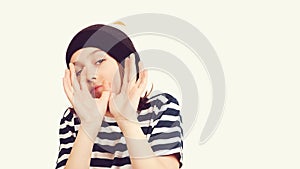 Excited boy having fun and posing at studio. Portrait of eleven years old boy. Boy wearing stylish woolen hat and tshirt