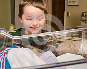 Excited boy meets his infant sibling after delivery