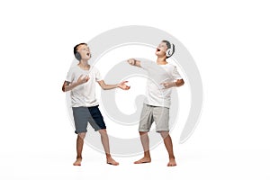 Excited brothers singing with closed eyes while listening music in headphones
