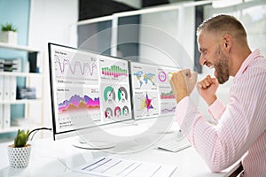 Excited Business Analyst Using Data Dashboard On Computer