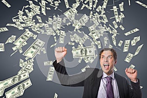 Excited business man with money rain against blue background