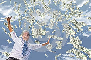 Excited business man with money rain against sky photo