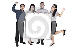 Excited business people showing empty board