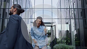 Excited business woman celebrating promotion in contemporary glass office facade
