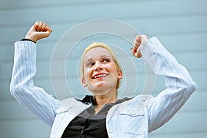 Excited business woman standing at office building