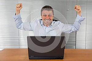 Excited businessman with arms up
