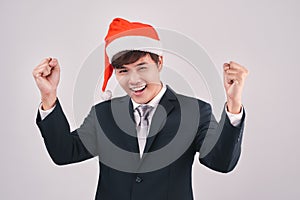 Excited businessman in black suit and santa hat isoalted on whit